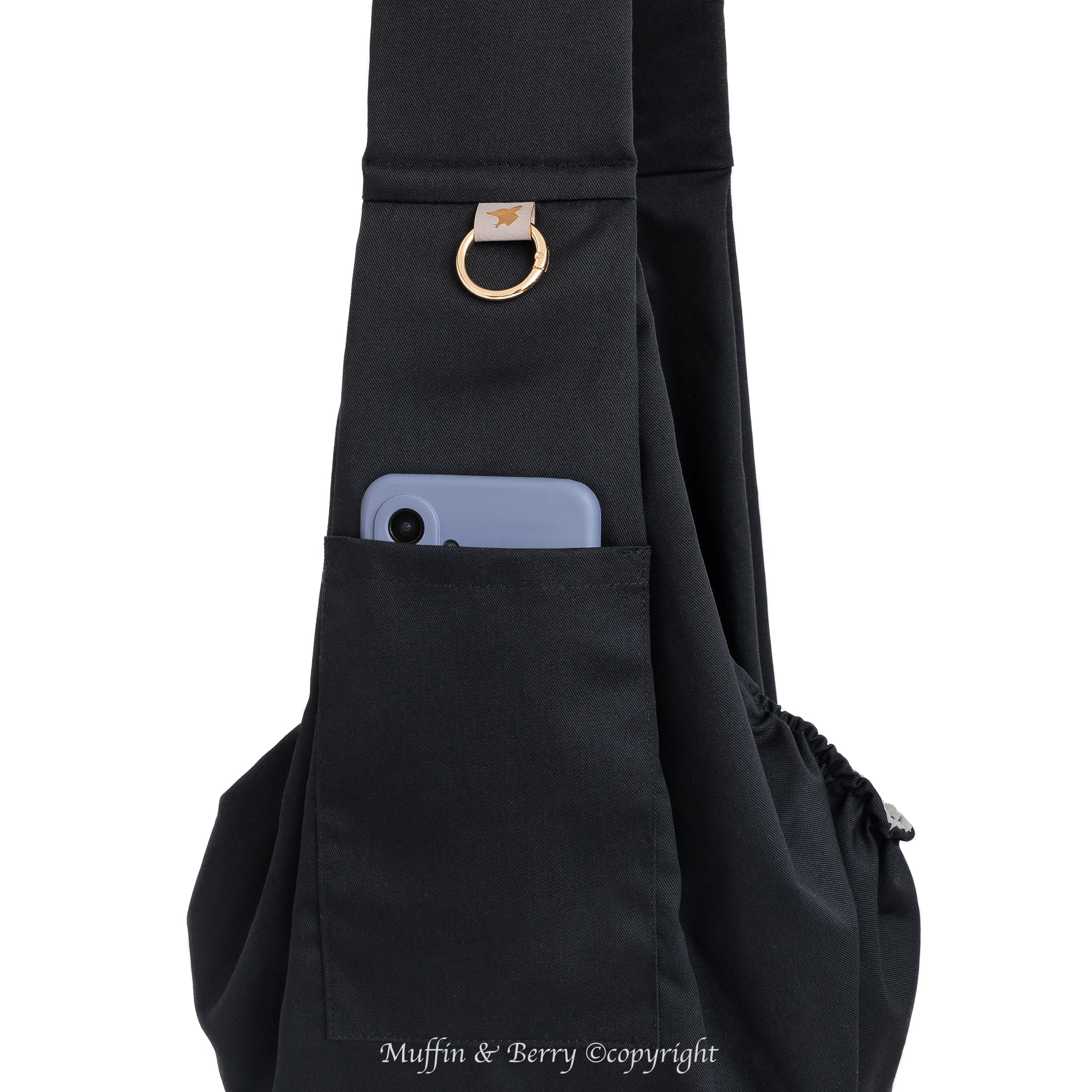Muffin & Berry Marco black pet sling bag close-up of front phone pocket with gold branded O-ring, stylish dog sling carrier with storage