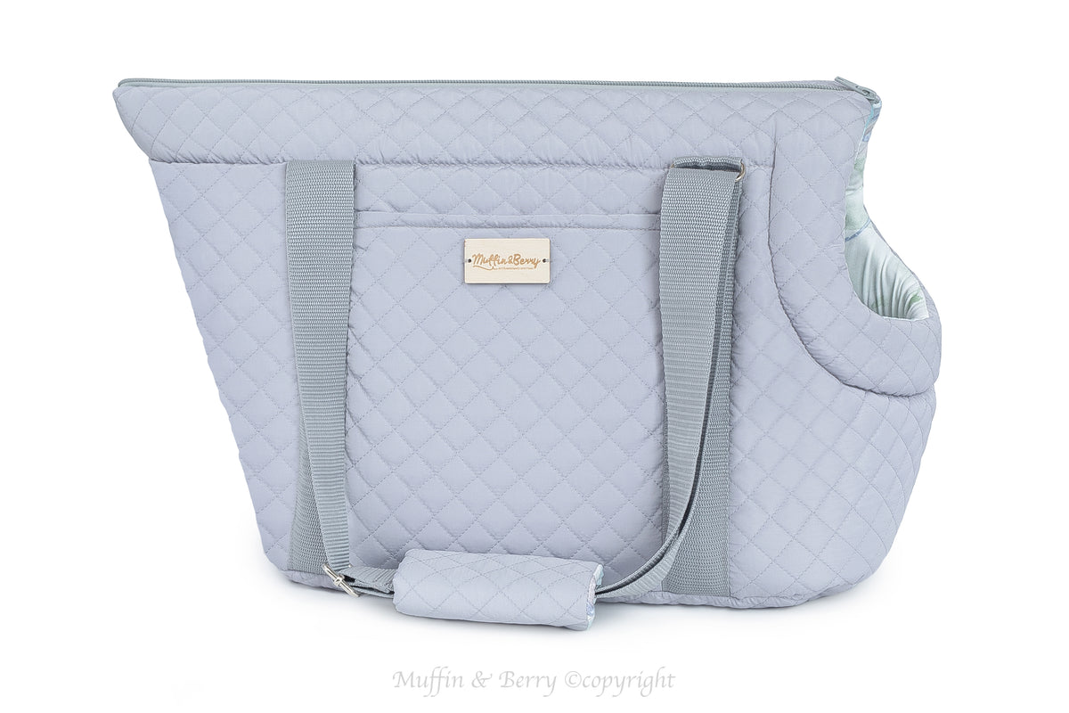 AUSTIN light grey quilted dog carrier bag side view on white background, outside pocket and adjustable shoulder strap visible, wooden Muffin & Berry label, by Muffin & Berry