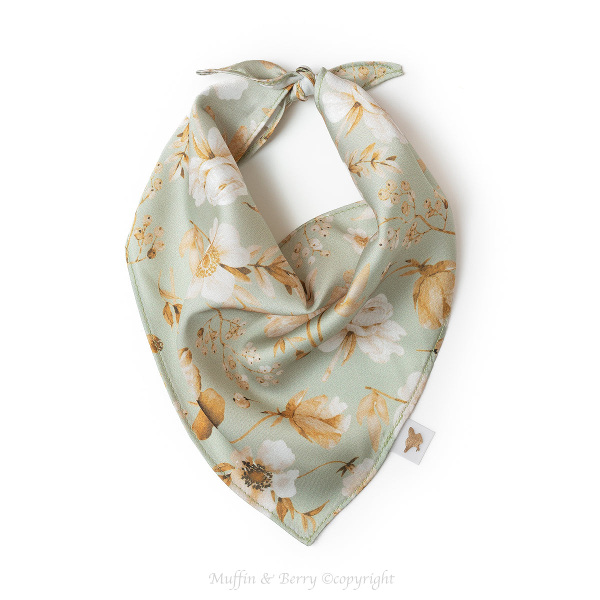 A sage green dog and cat bandana SKYLER featuring a white and gold floral print, tied in a triangular knot on a clean white background, by Muffin & Berry