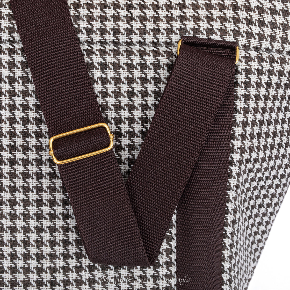 Close-up dark brown adjustable shoulder straps with gold-tone hardware on KINSLEY chocolate houndstooth dog carrier by Muffin & Berry