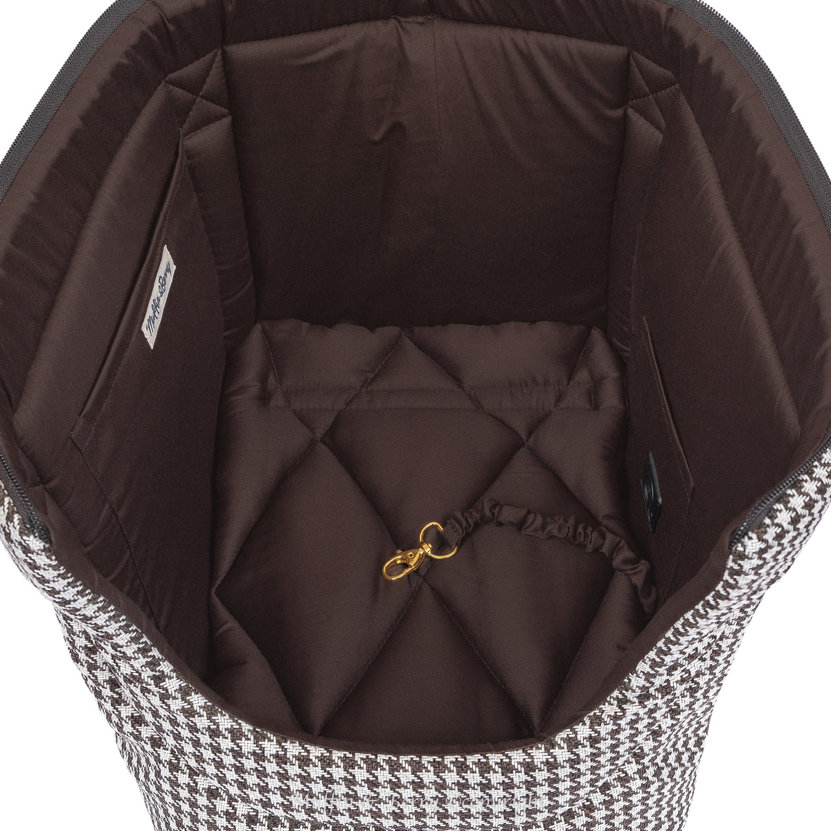 Interior top view of KINSLEY dog carrier bag showing chocolate brown quilted cushion and gold safety leash clip, by Muffin & Berry