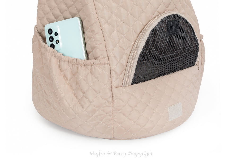 Outside pocket of beige quilted front pet carrier with phone inside, showing storage capacity – by Muffin & Berry