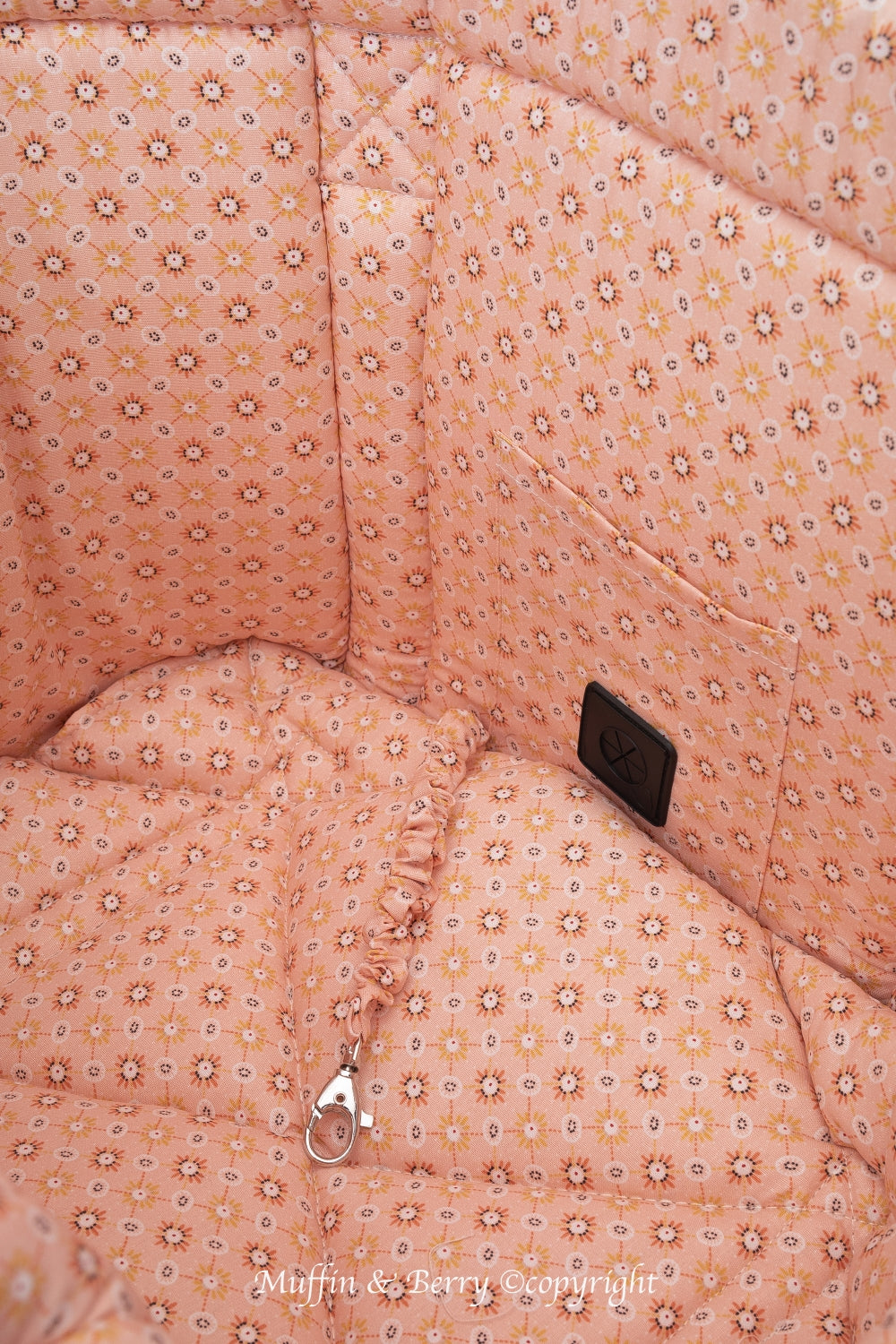 Interior close-up of AMELIA dog carrier bag showing peach floral cotton lining, waste bag dispenser pocket and silver safety leash clip, by Muffin & Berry